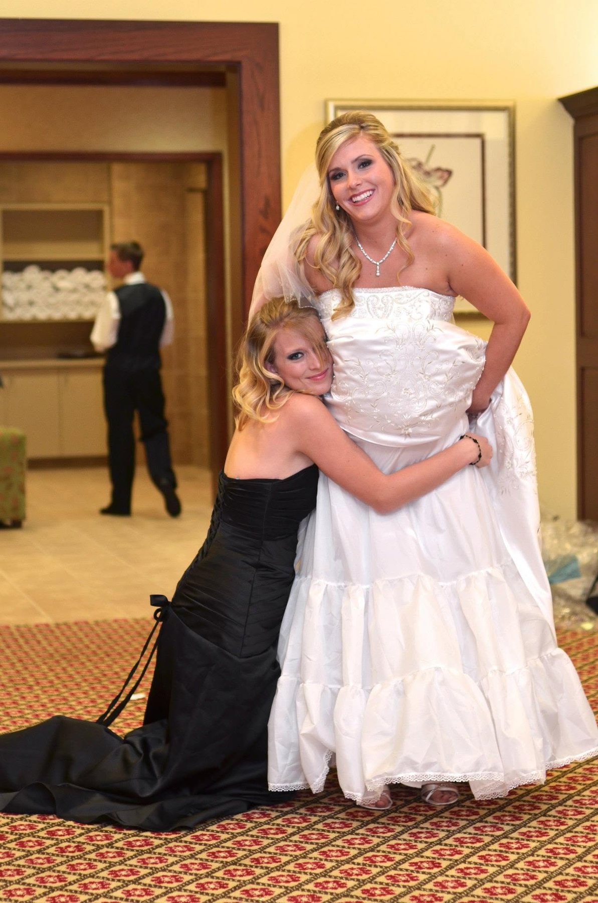 Bride sharing a joyful getting-ready moment with a bridesmaid