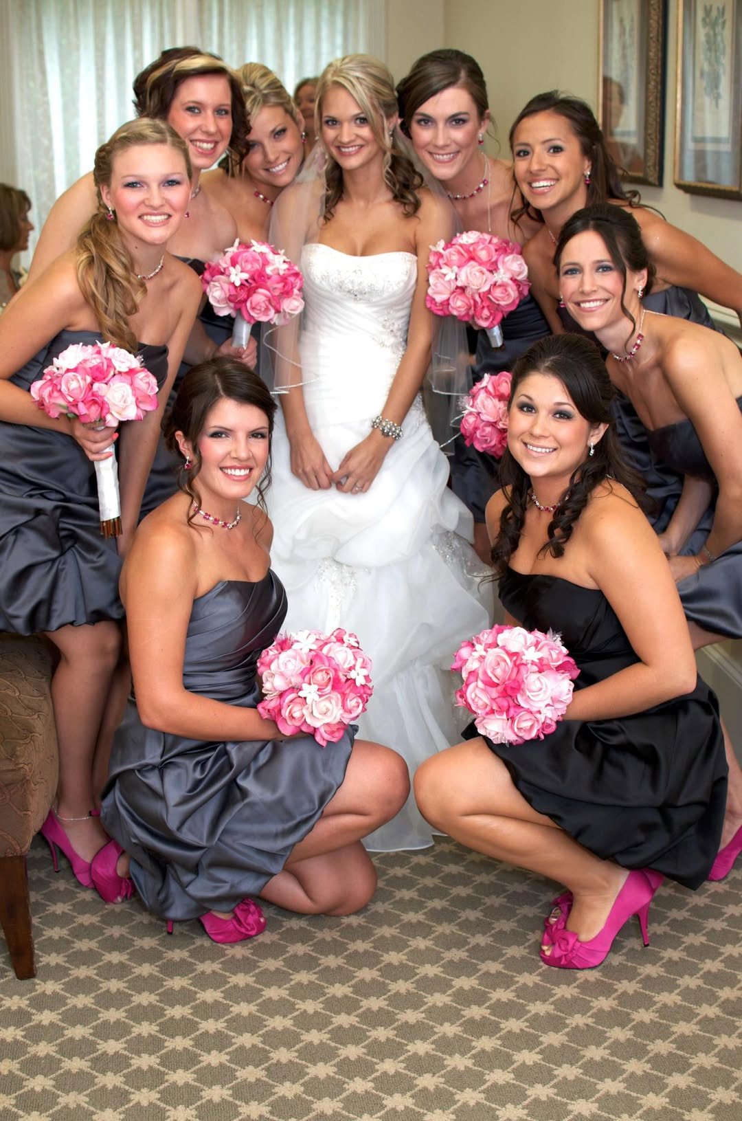 Bride surrounded by bridesmaids holding pink bouquets
