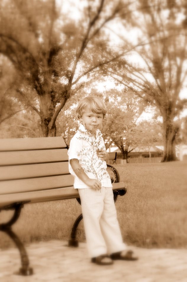 Sepia portrait of a child near a park bench