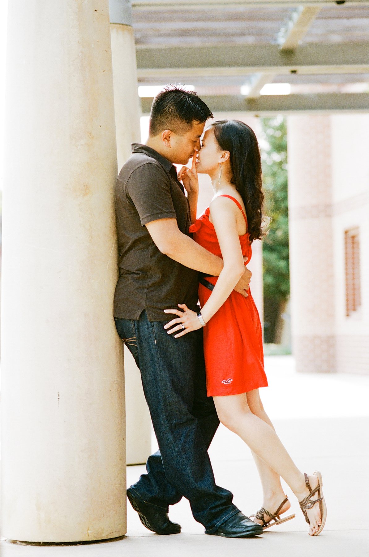 Engaged couple sharing a quiet moment beside a column