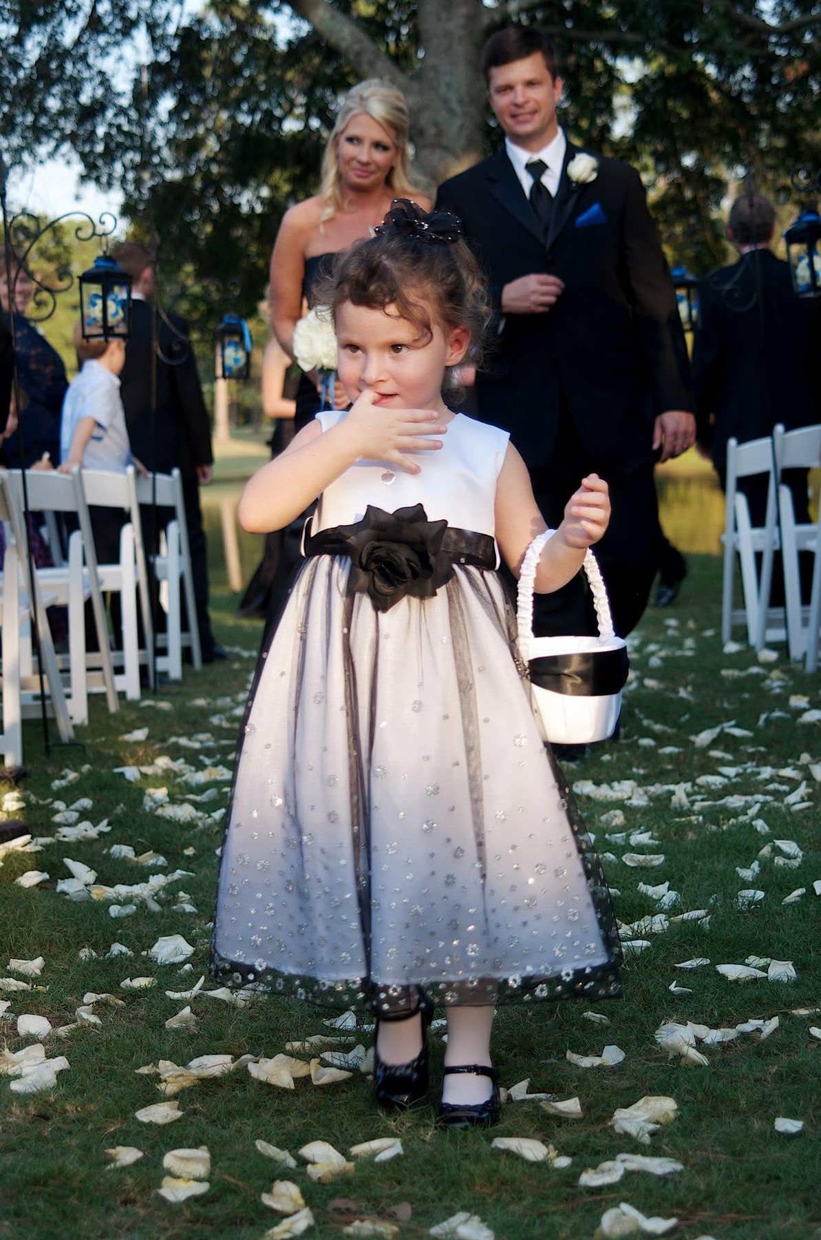 Flower girl walking down an outdoor wedding aisle
