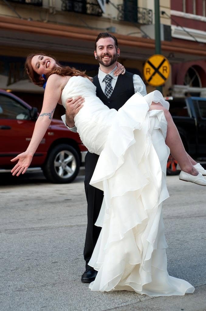 Groom carrying a laughing bride outdoors