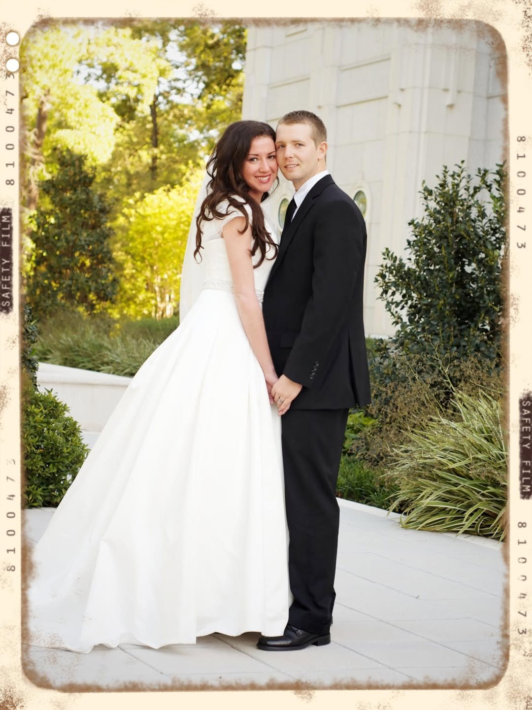Newlyweds posed in a vintage film-style frame