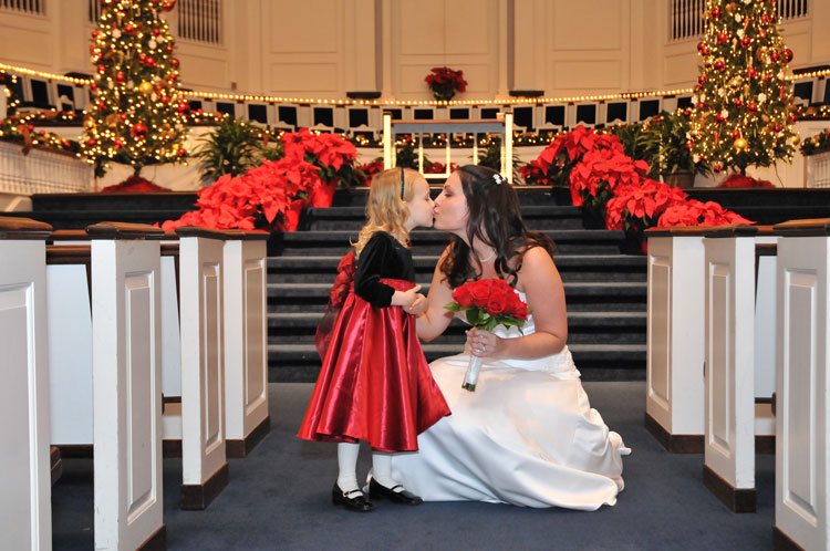 Bride sharing a tender moment with a child at a winter wedding